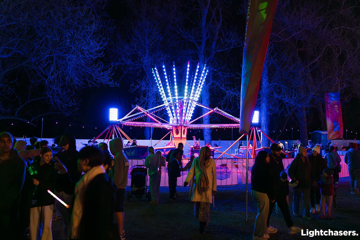 Crowd enjoying an illuminated amusement ride at night