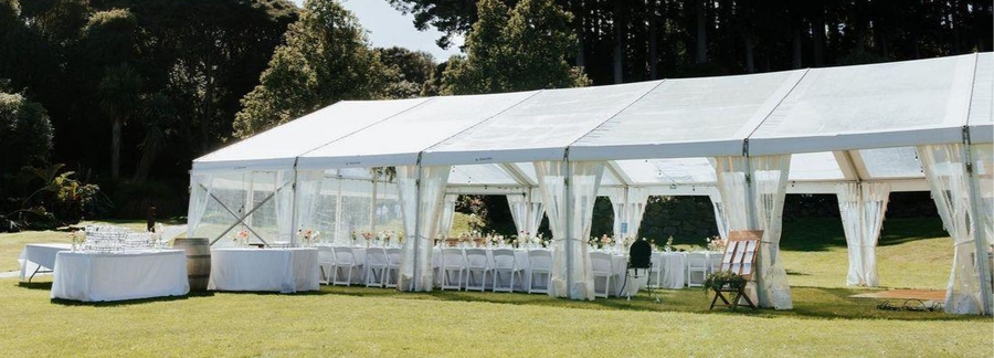 White chairs set up under a marquee overlooking the harbour